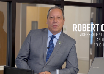 Robert Clougherty standing at a desk with his laptop
