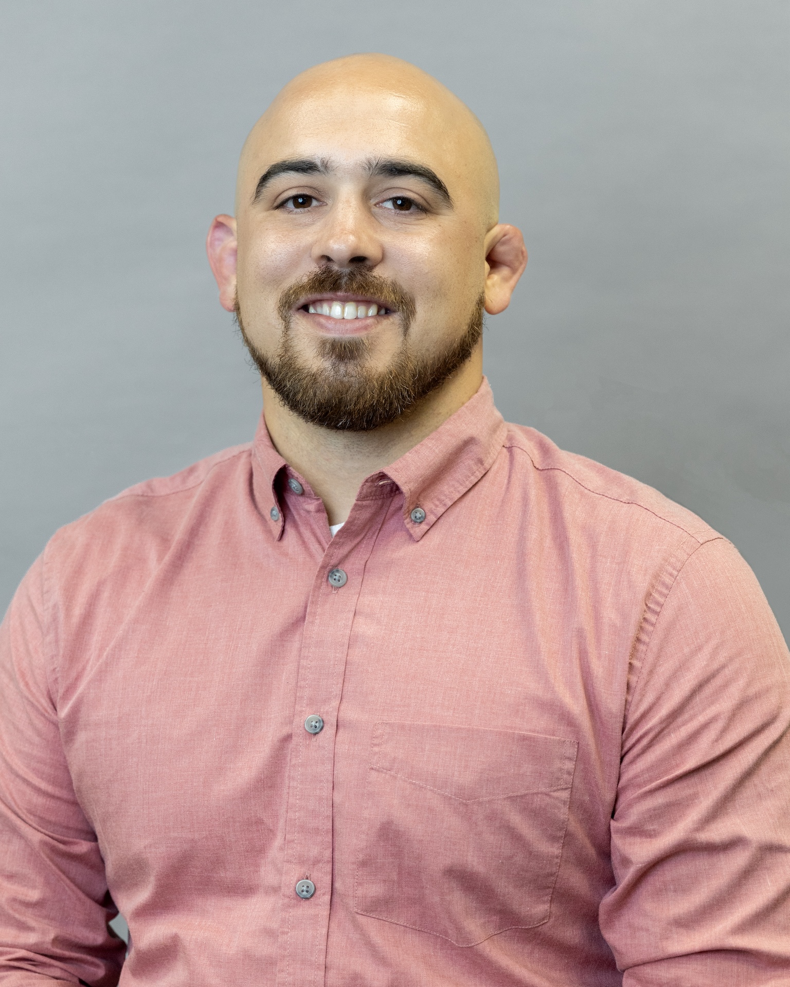 Brendan Guarino, Felician professor, smiling in salmon colored shirt
