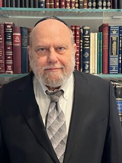 Felician professor David Steinman headshot shows man in a dark suit with a tie.